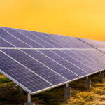 Utility-scale ground mount solar structure installed in an open landscape during sunset.