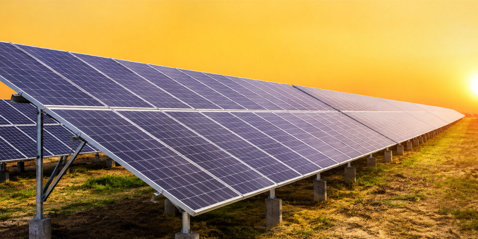 Utility-scale ground mount solar structure installed in an open landscape during sunset.